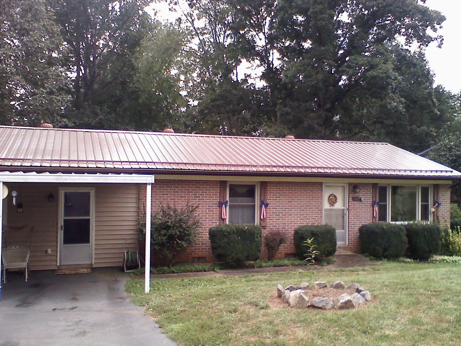 Bronze metal roof and carport on a brick ranch home — Roof Repair work by our crew in Ramsay