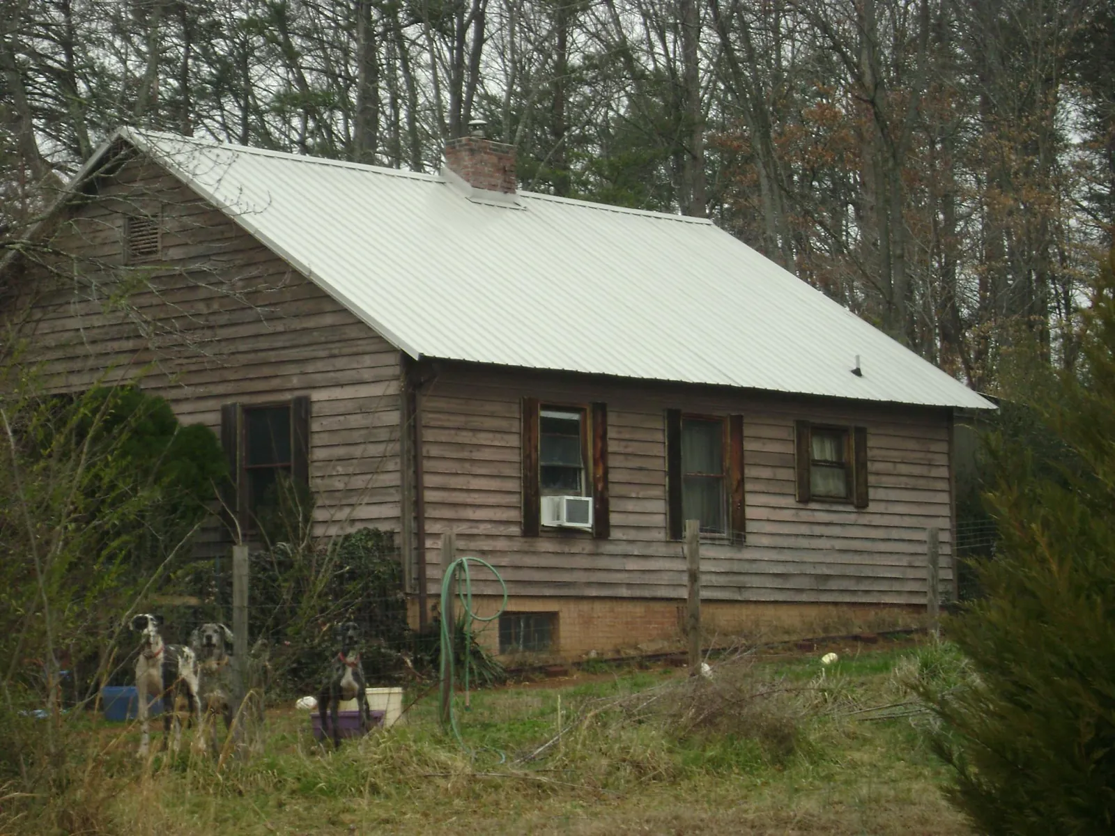 White metal roof on an old wood sided farmhouse, from a Metal Roof Installation job in Ramsay